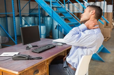 Warehouse manager working on computer in a large warehouse