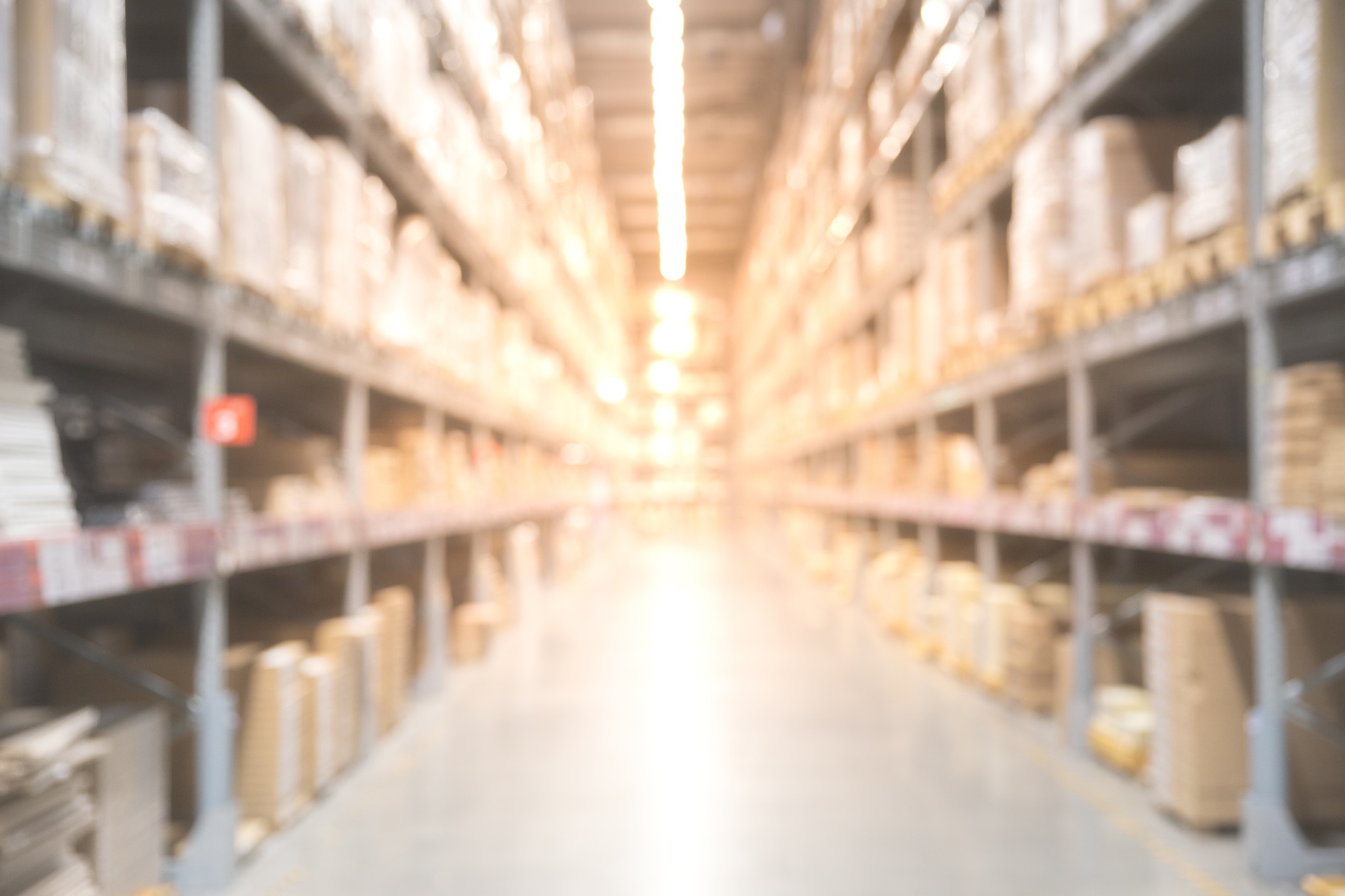 defocused-blurred-boxes-on-rows-of-shelves-in-warm-light-warehouse-background_t20_OpZ4vO
